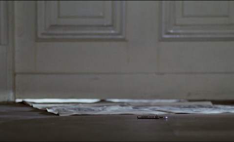 The bedroom key lands just past the newspaper.