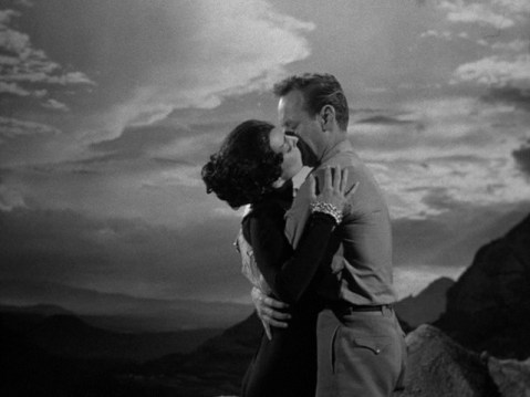 Doug and Lambda kiss against the cloudy backdrop of the cat-women's underground world.